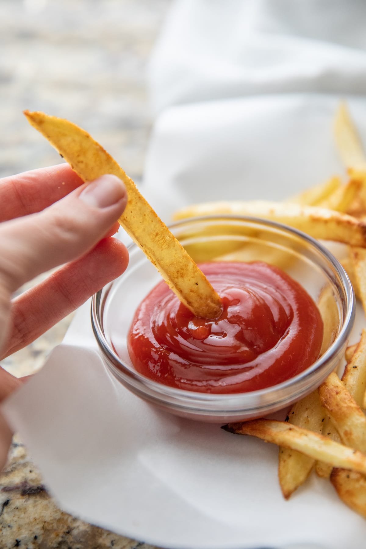 dipping french fry into ketchup