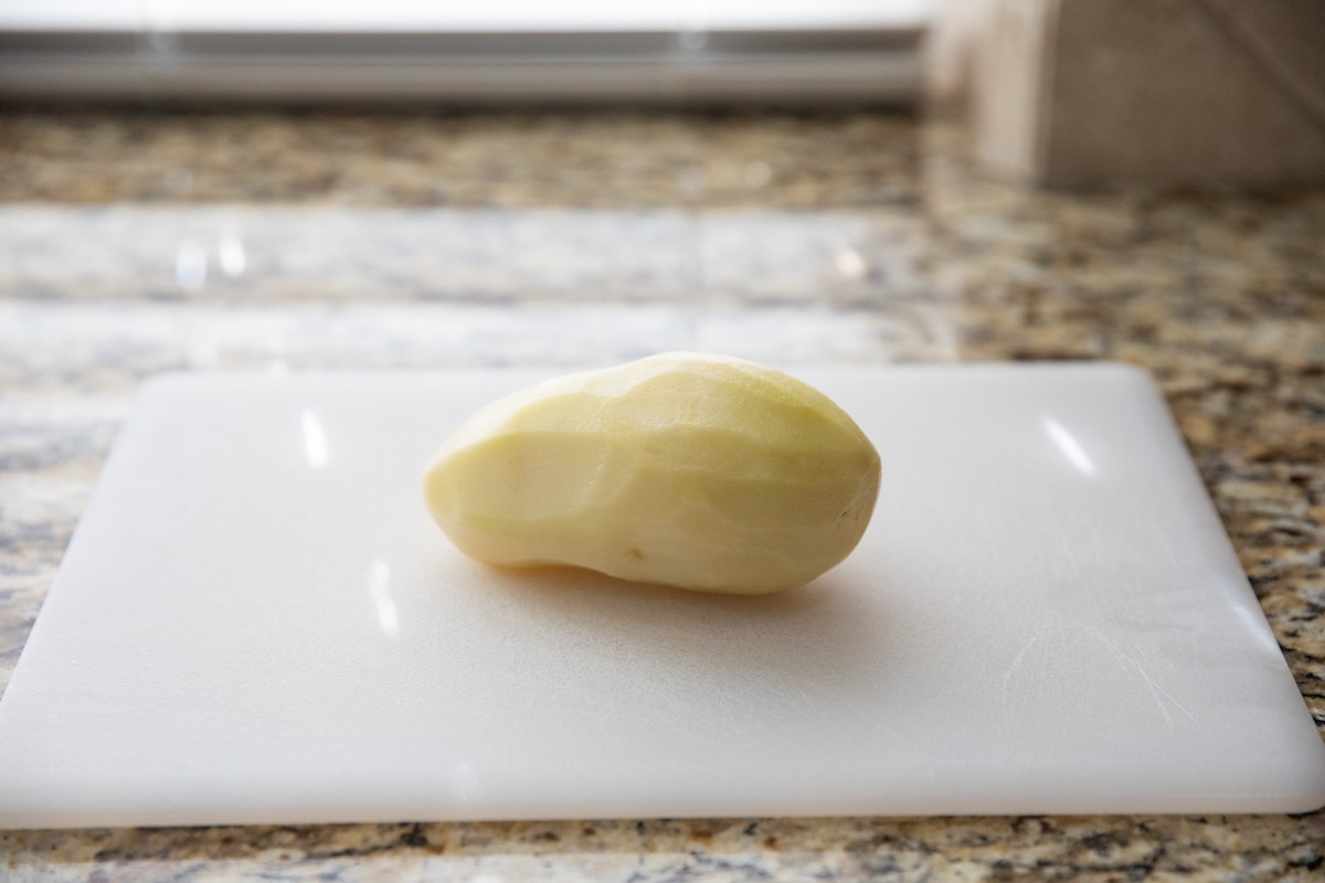 peeled potato on cutting board
