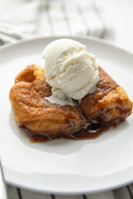two apple dumplings on plate with ice cream