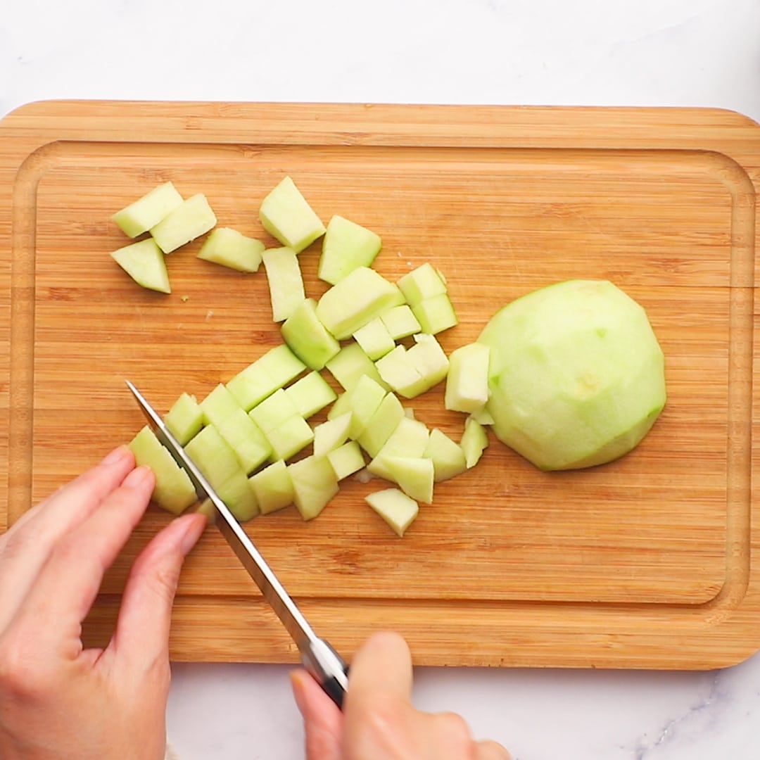 Woman chopping green apples for Apple Fritters