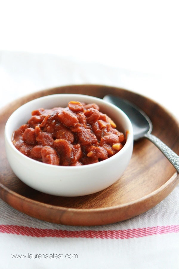 boston baked beans in a small white bowl with a spoon next to it
