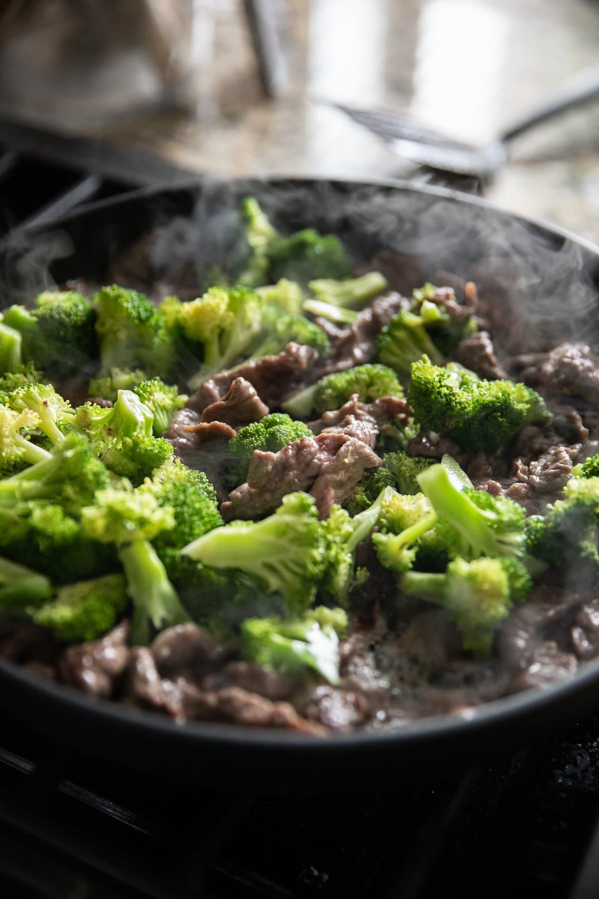 cooking beef and broccoli in pan