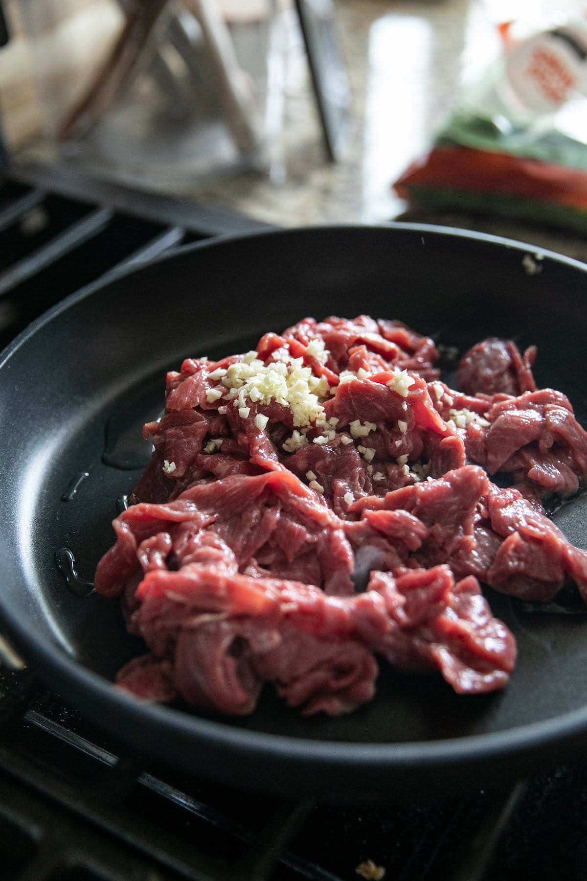 raw beef and garlic in skillet