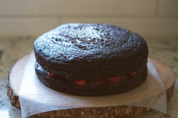 two chocolate cake rounds with cherry filling in between them