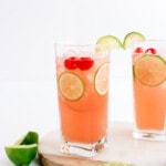 cherry limeade in a glass with lemon wedges