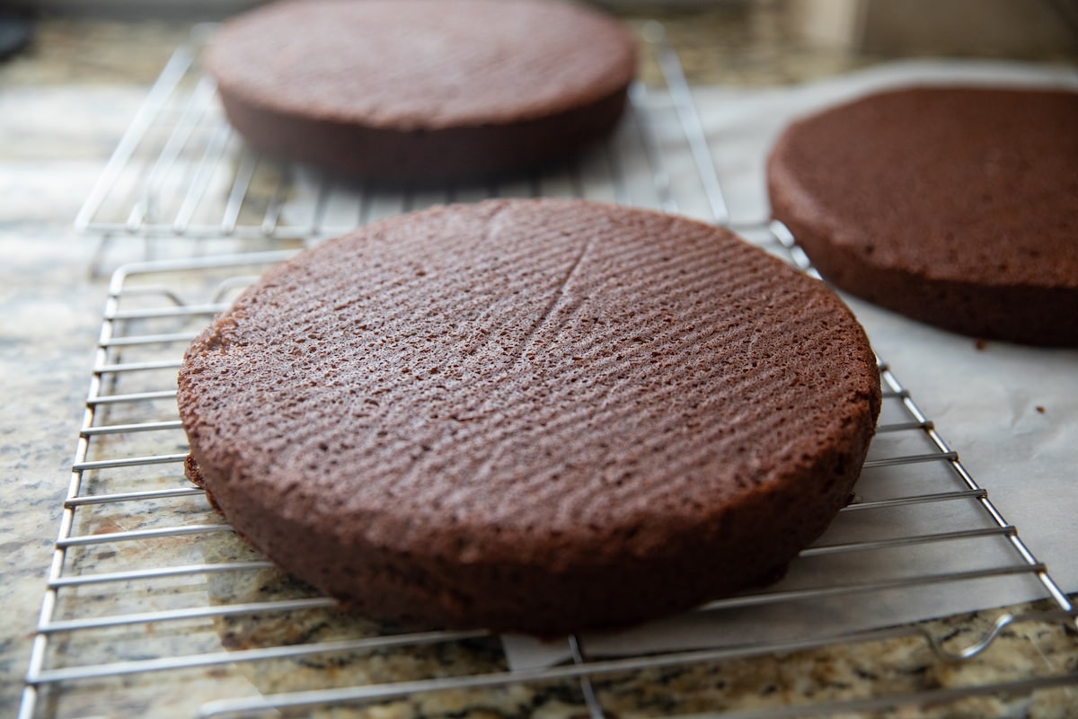 round chocolate cakes cooling on cooling racks