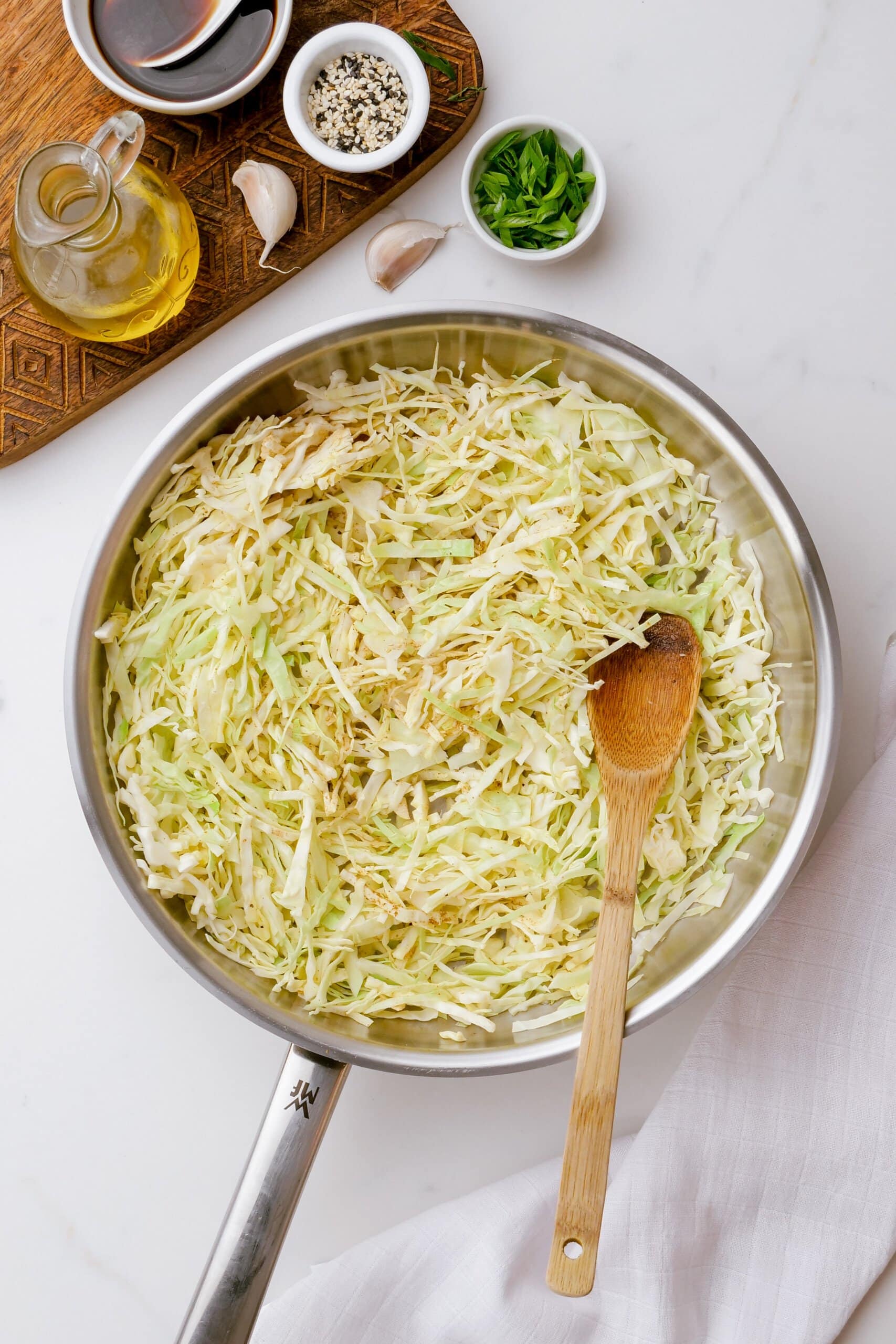 cabbage in a cooking pot with a wooden spoon