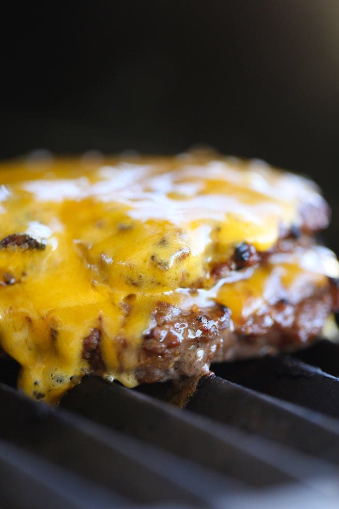 grilled burger on a grill with cheese
