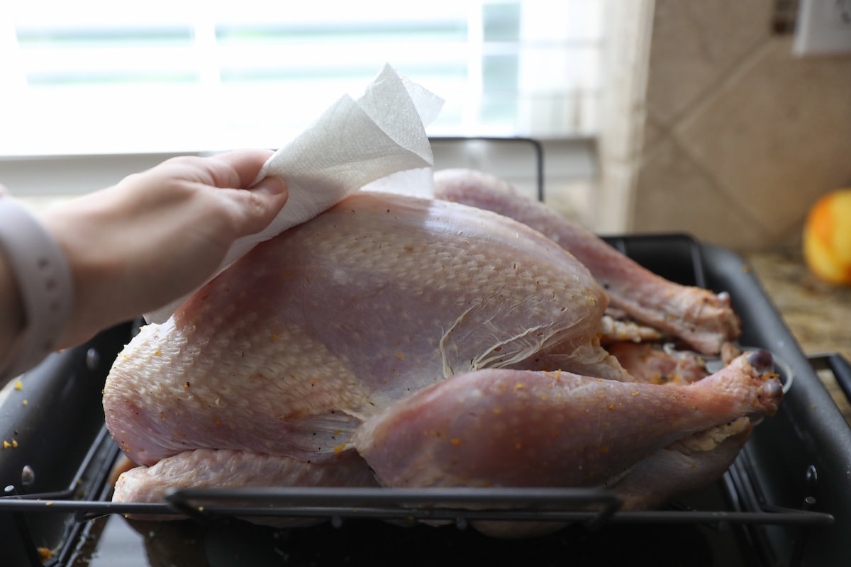 wiping turkey with paper towel