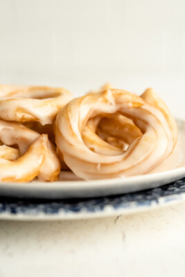 side view of french crullers on a plate