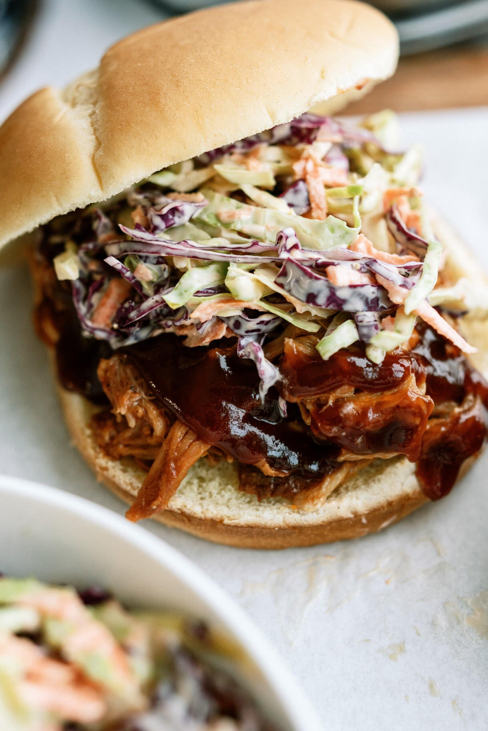 close up of pulled pork sandwich with coleslaw on it