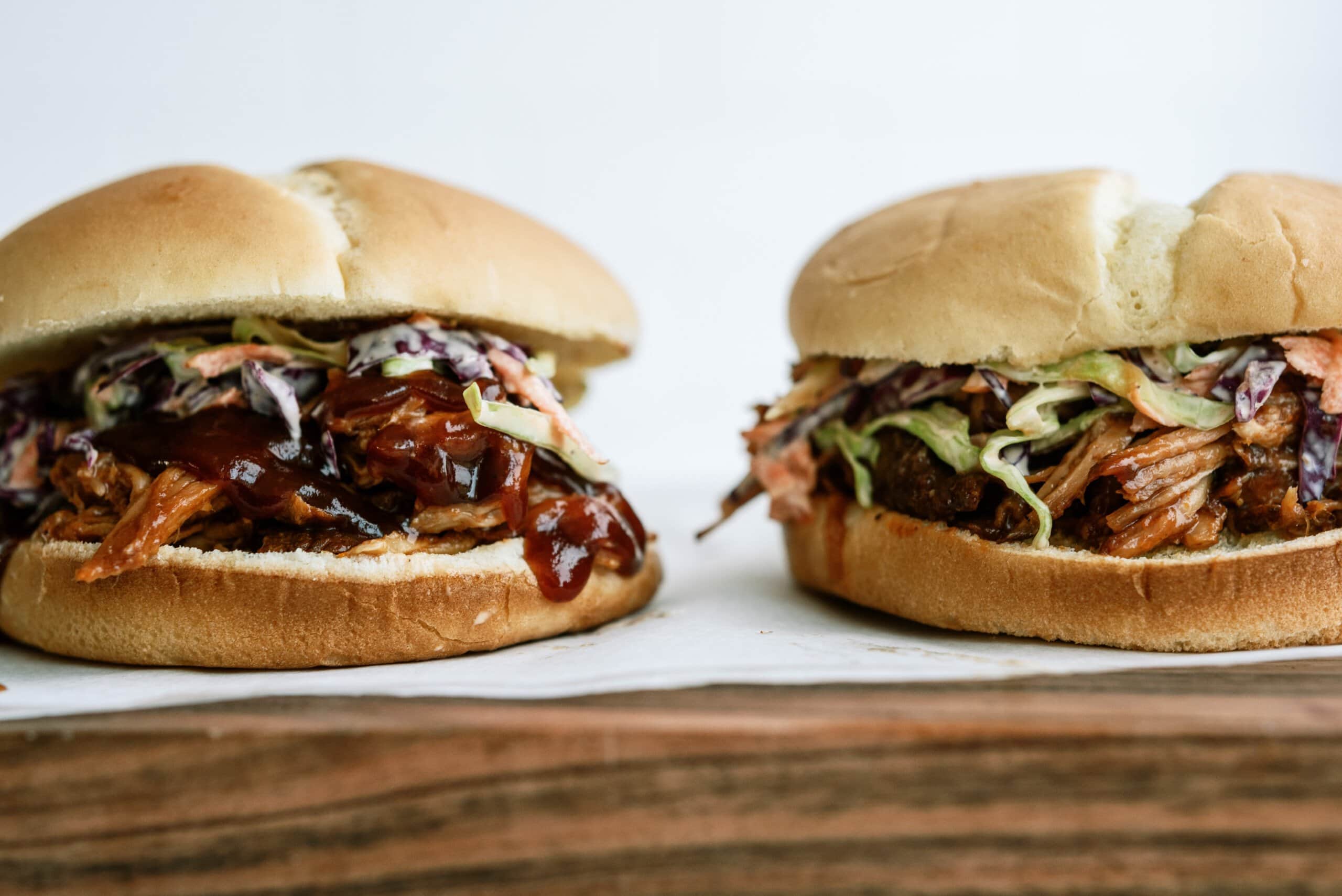 two pulled pork sandwiches photographed from the side