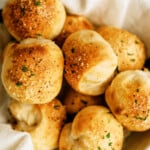 close up of parmesan bread bites in a bowl lined with