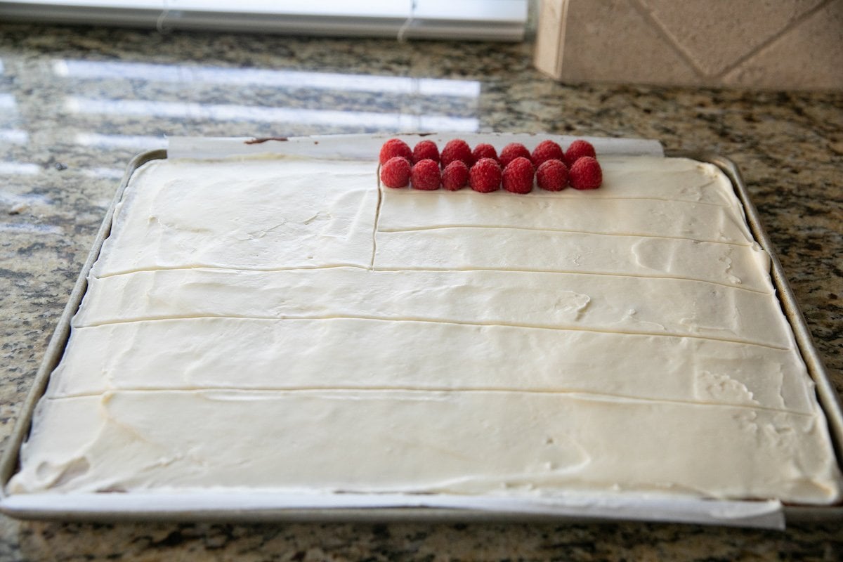 starting to decorate sheet cake with berries