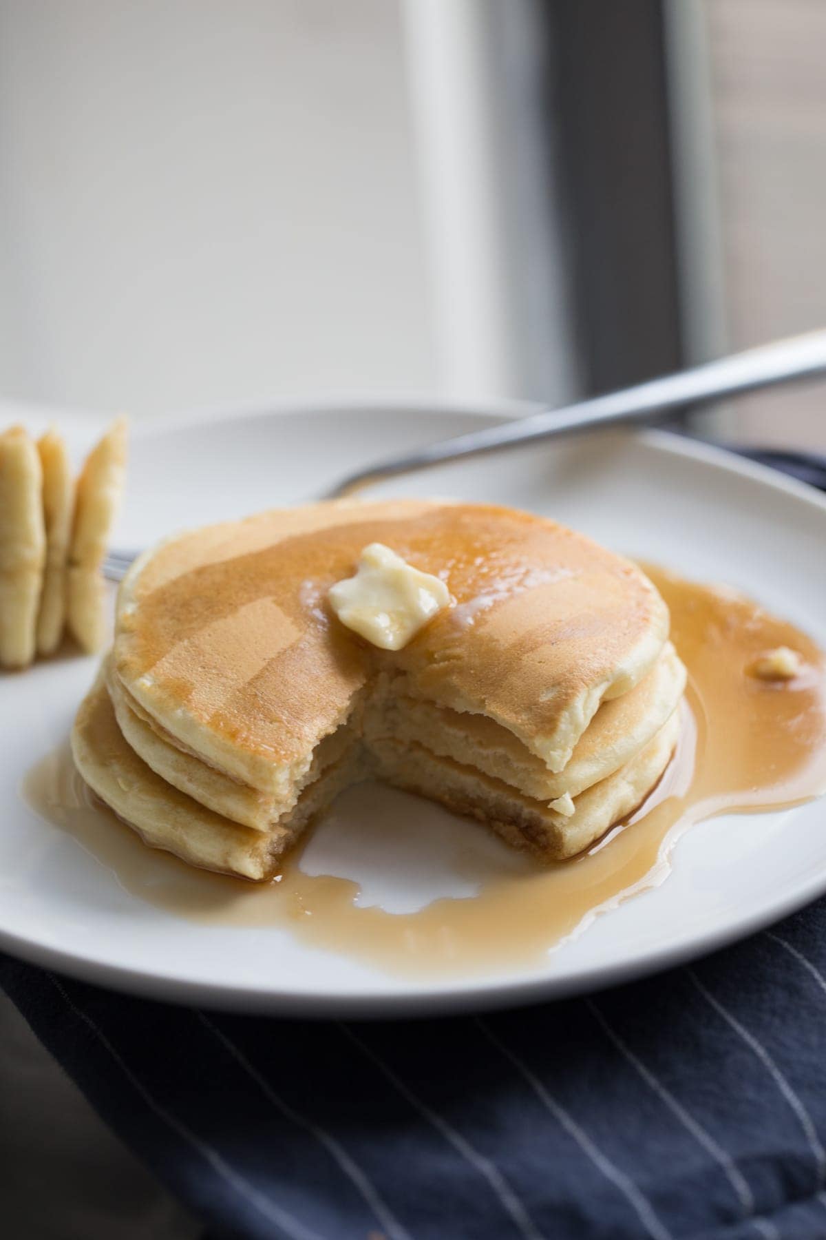 Pancake stack with syrup and butter on a plate