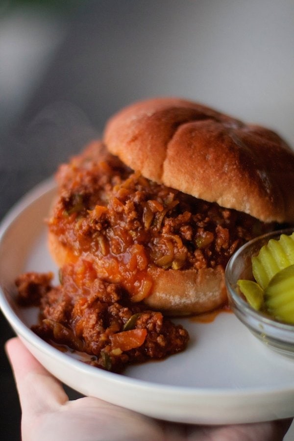 sloppy joes sandwich with meat made in the crock pot all on a white plate