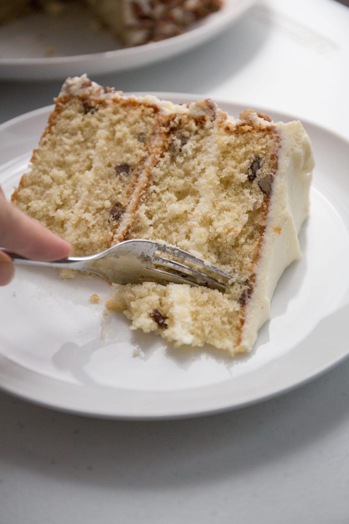 Cake slice on a plate with a fork taking a bite