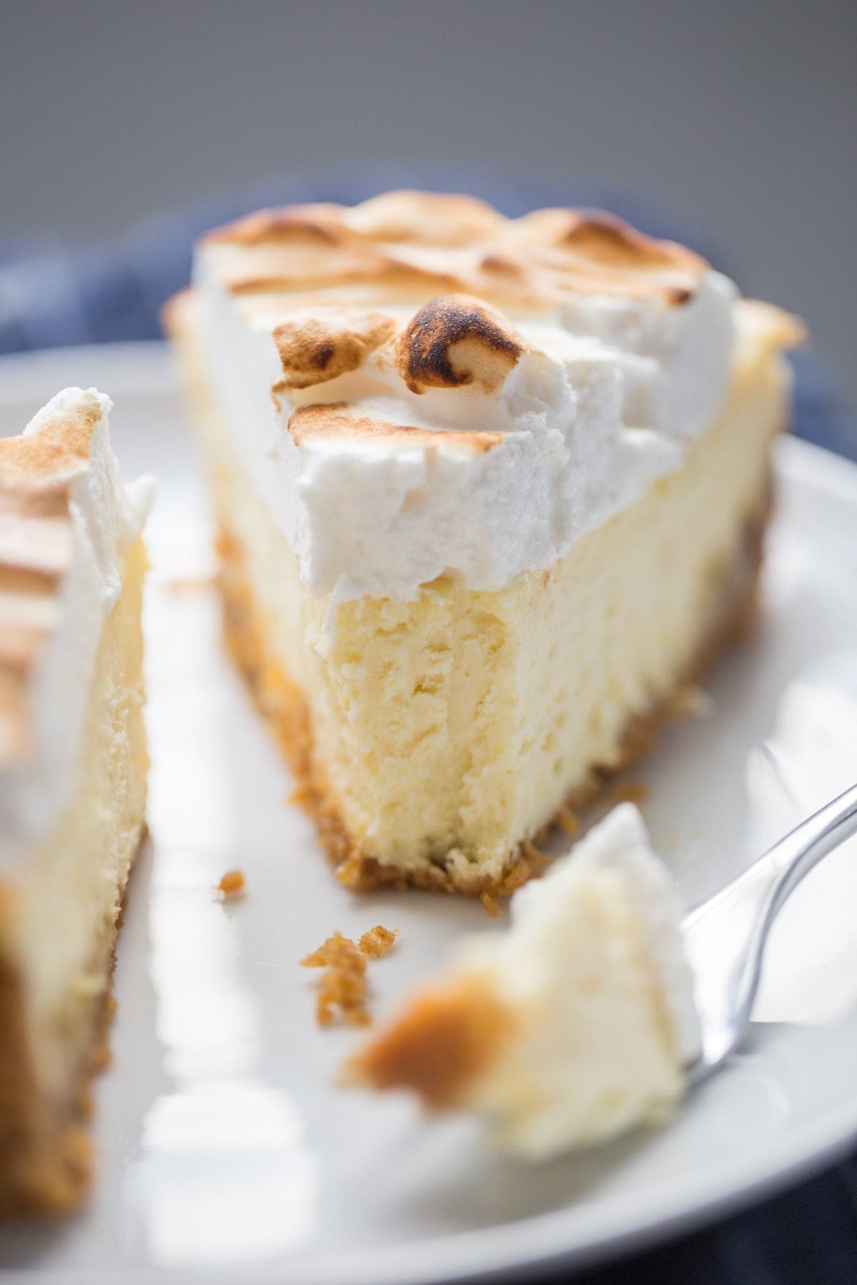 slice of lemon meringue cheesecake with a bite taken out of it