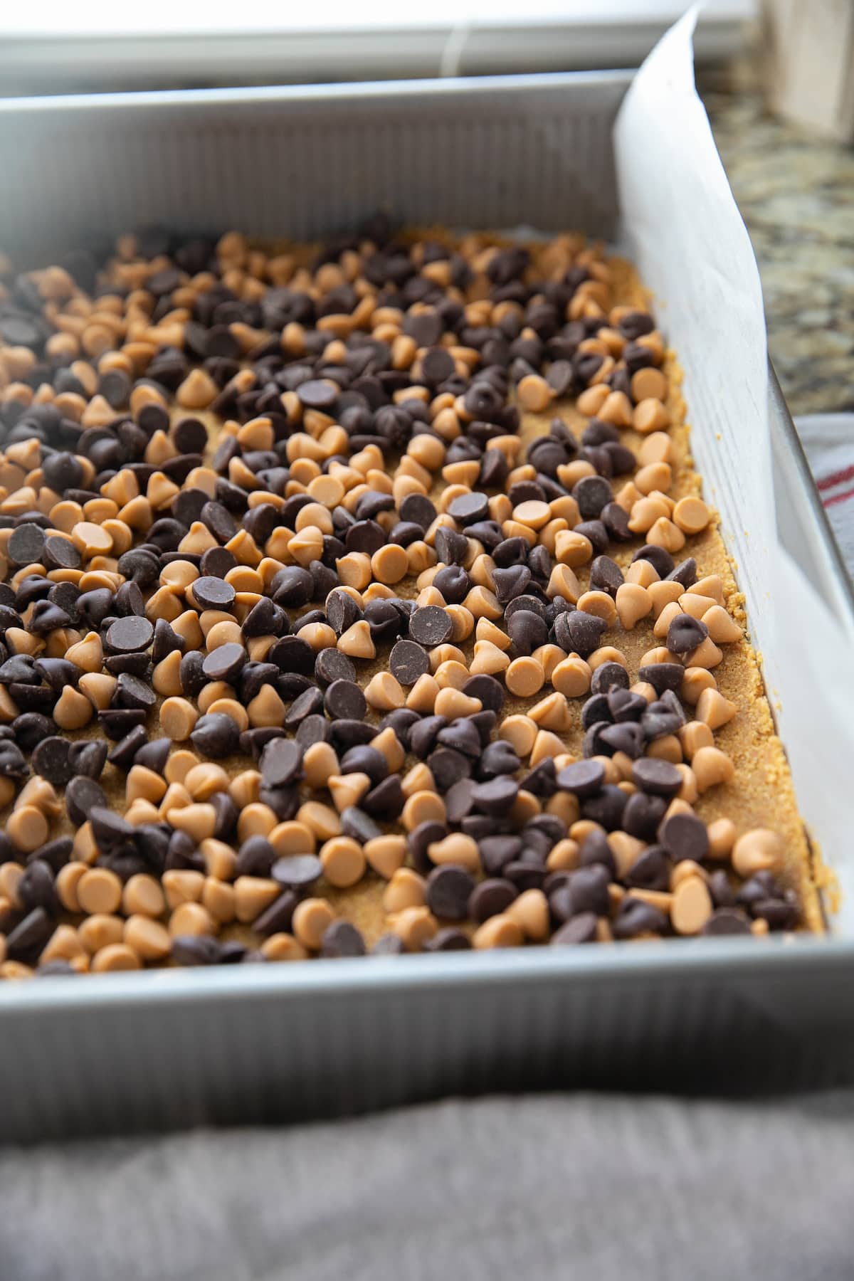 chocolate and butterscotch chips on top of graham cracker crust all in a baking dish