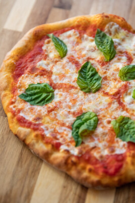 baked margherita pizza on cutting board