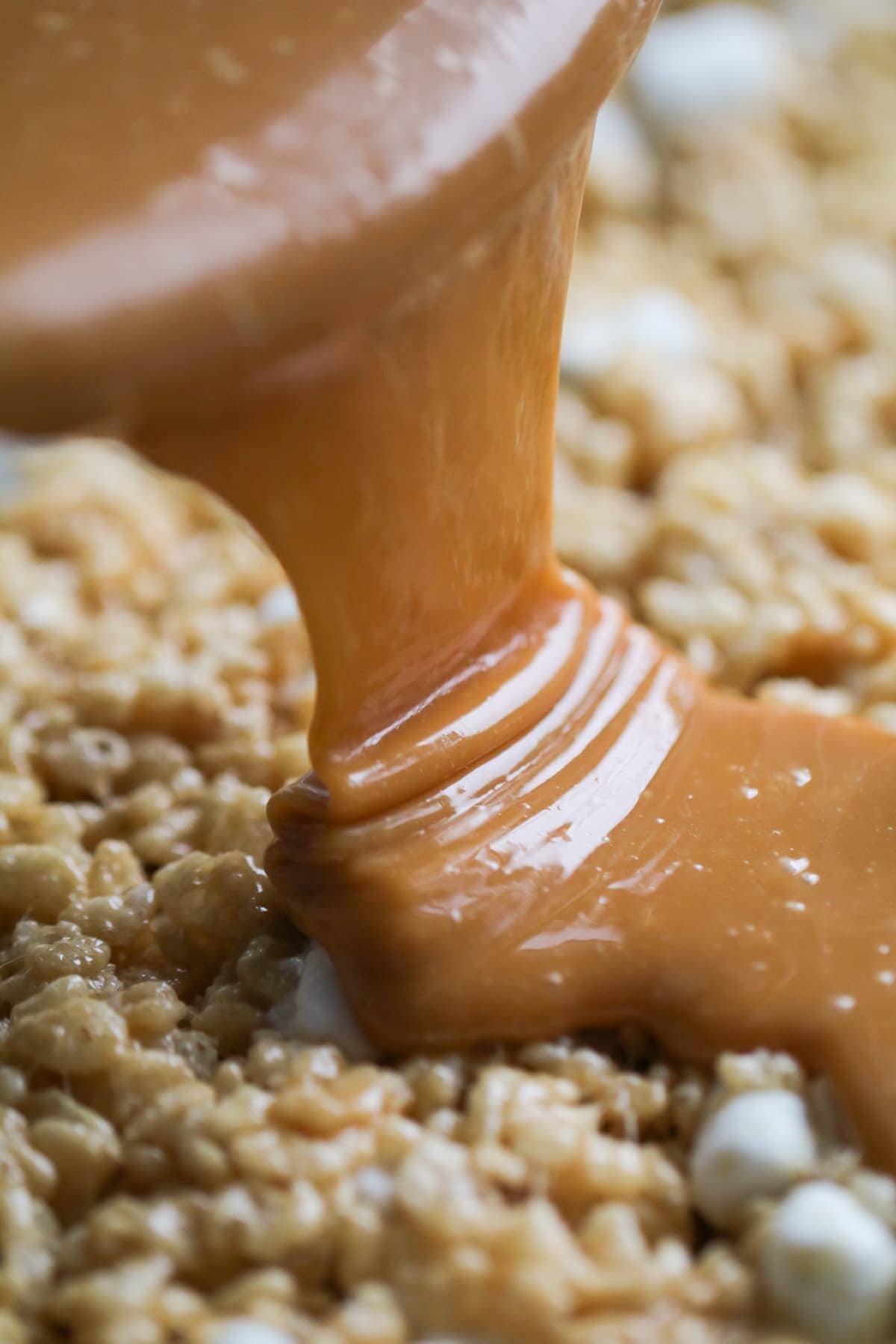 Pouring caramel over peanut butter rice krispie treats