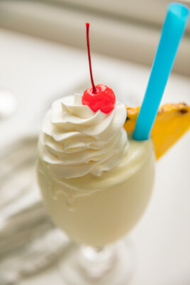 pina colada recipe in cup with straw