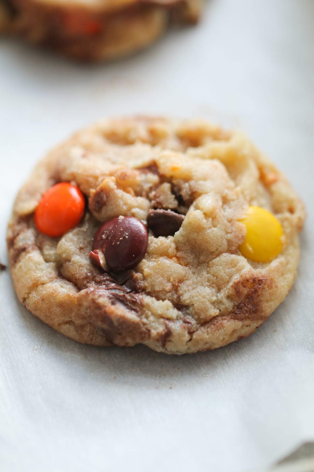 Butterfinger Reese's Pieces Cookie on parchment paper