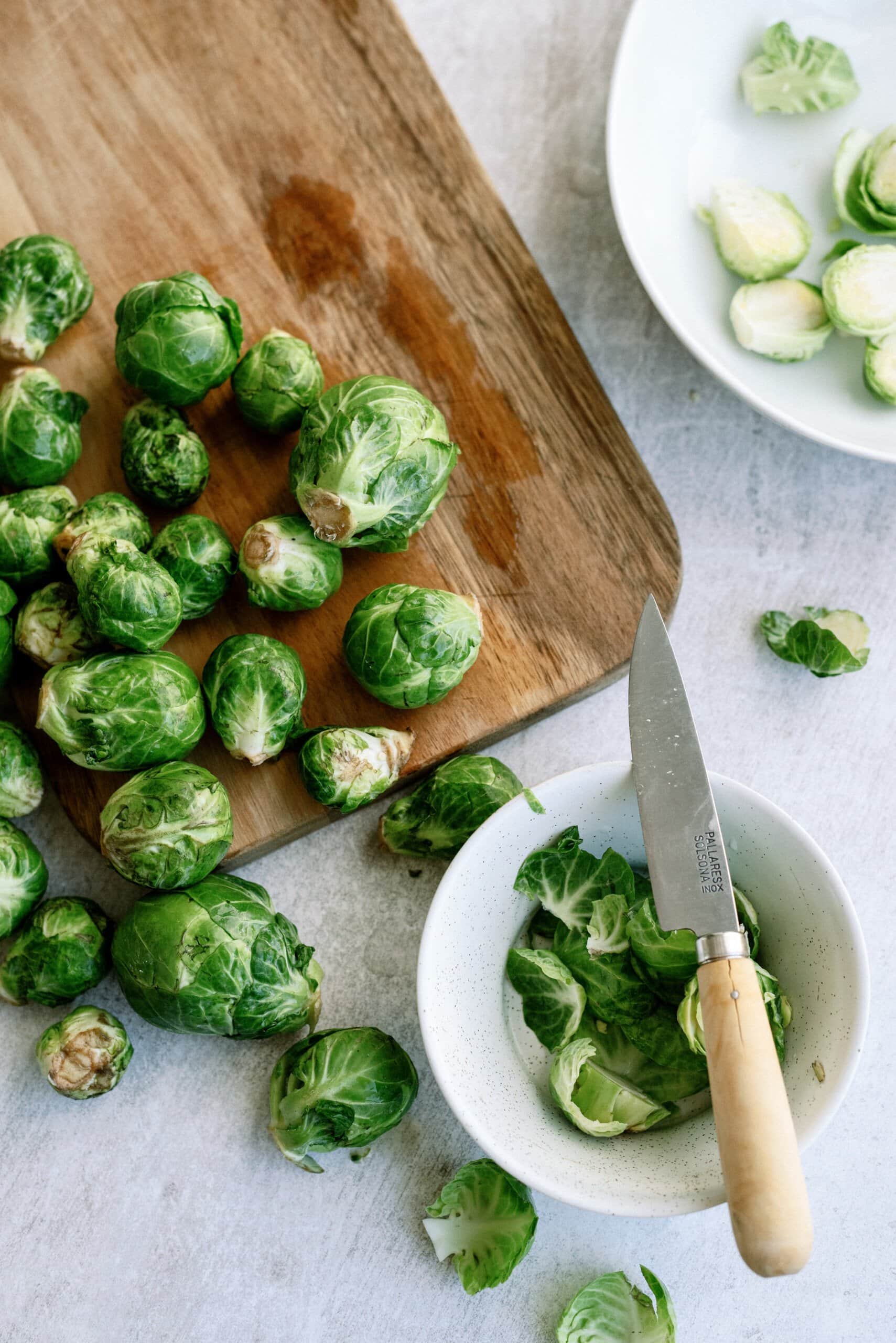 cutting brussel sprouts on a cutting board