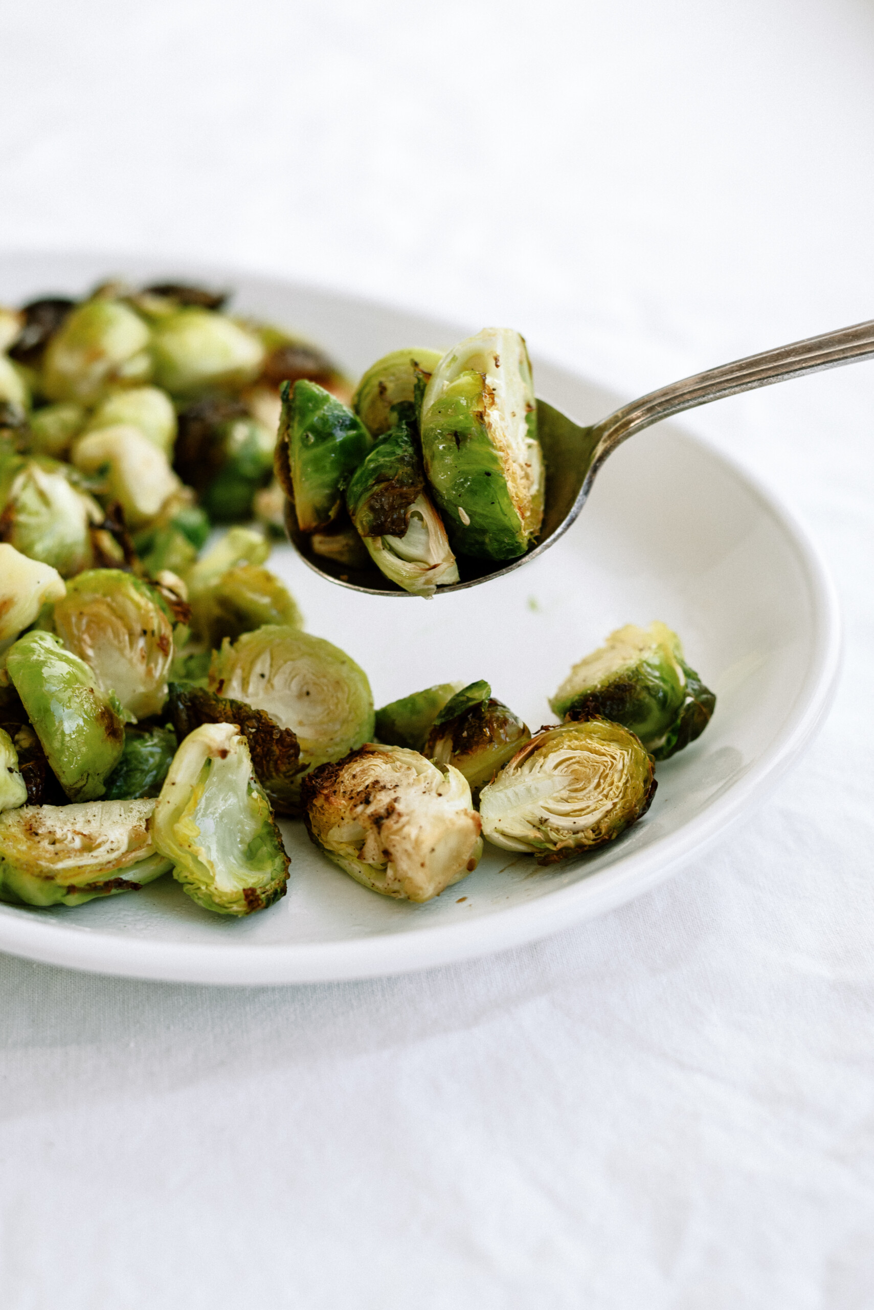 a spoon scooping up baked brussel sprouts