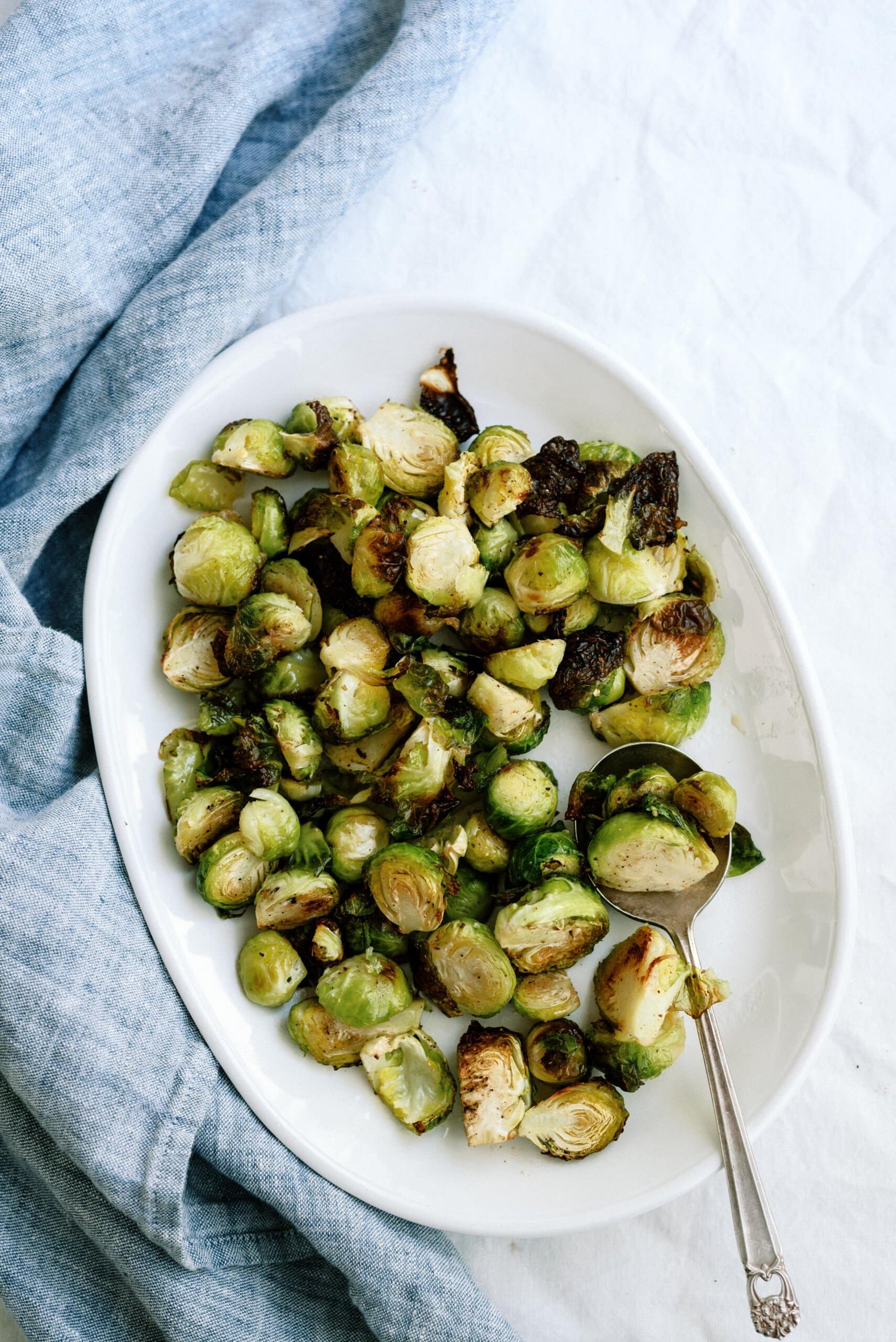 top down view of roasted brussel sprouts on a white serving dish