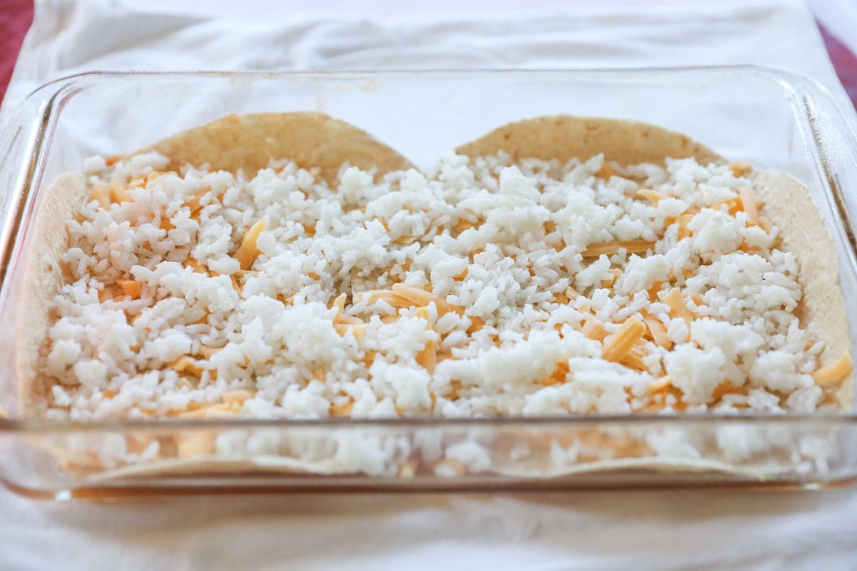 tortillas, rice and cheese layered in baking pan