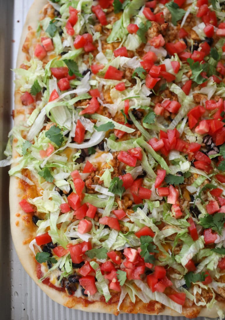 taco pizza topped with lettuce and tomato