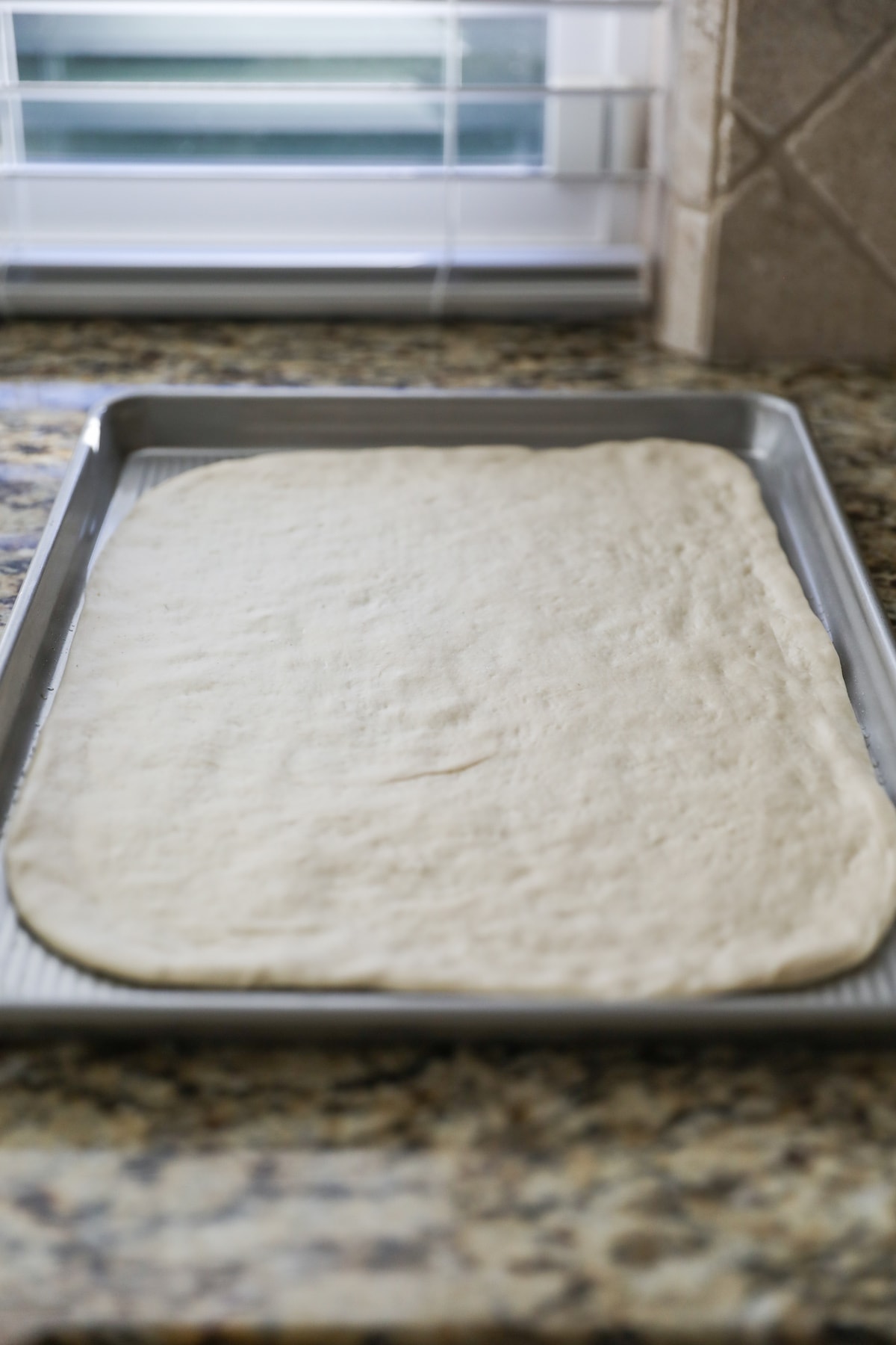 pizza dough on baking sheet