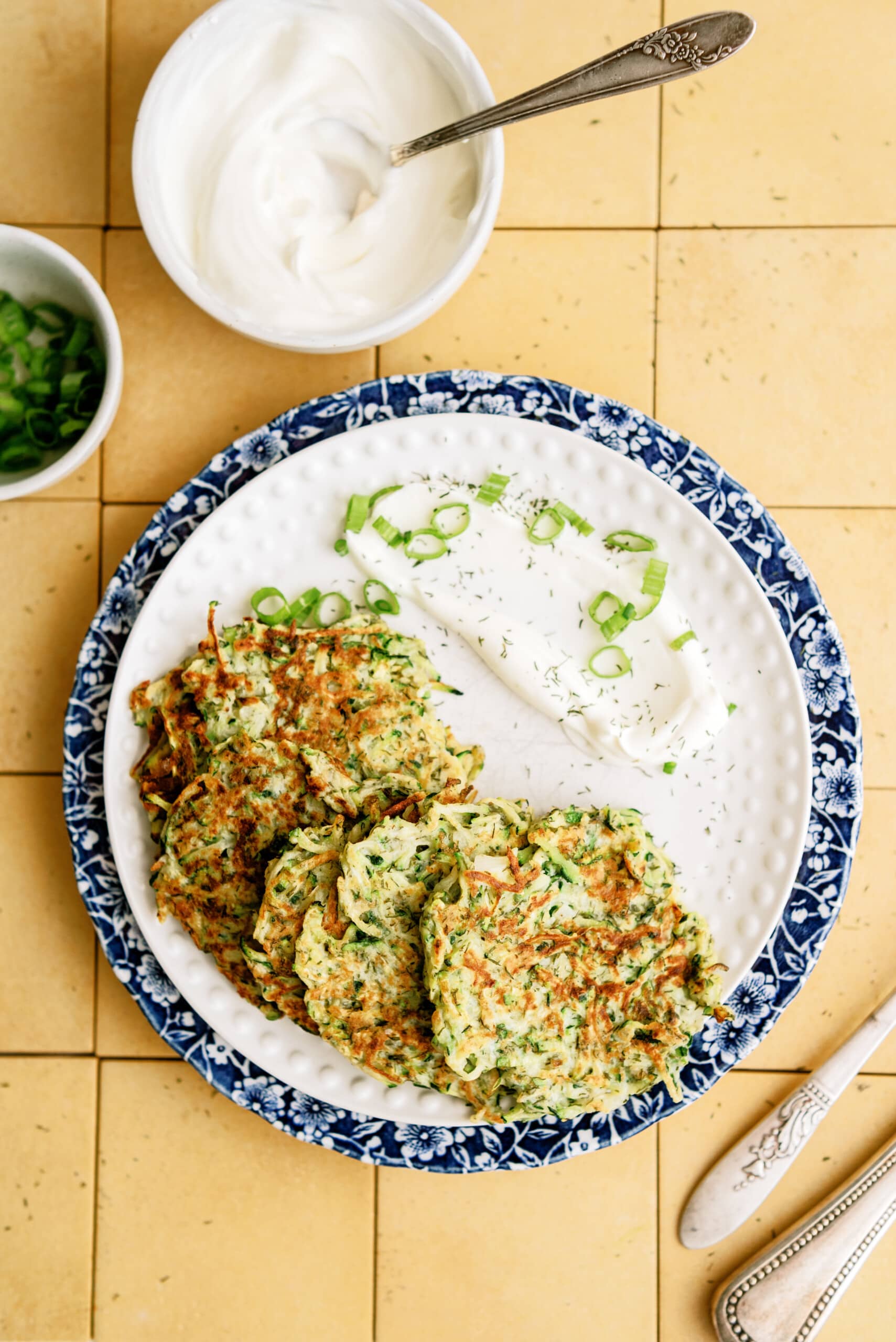 zucchini-fritters on plates with sauce
